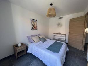 a bedroom with a large bed and a night stand at Appartement Calvi, 3 pièces, 4 personnes - FR-1-63-339 in Calvi