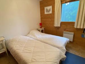 a bedroom with a white bed and a window at Appartement Crest-Voland, 3 pièces, 6 personnes - FR-1-733-140 in Crest-Voland