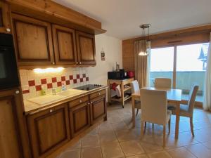 a kitchen with wooden cabinets and a table and a dining room at Appartement Crest-Voland, 3 pièces, 6 personnes - FR-1-733-140 in Crest-Voland