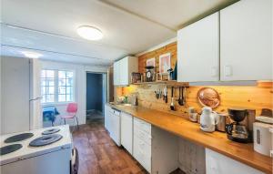 a kitchen with white cabinets and a wooden counter top at Beautiful Home In Nedstrand With Wifi And 4 Bedrooms in Nedstrand