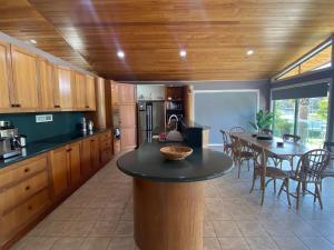 a kitchen with a table and a dining room at 56 Culgoa Crescent, Pambula Beach in Pambula Beach