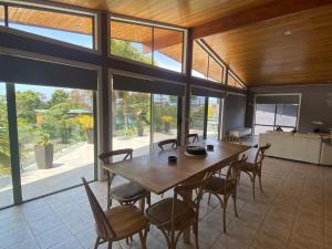 a large dining room with a wooden table and chairs at 56 Culgoa Crescent, Pambula Beach in Pambula Beach