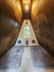two beds in a room with a window at D'flora Glamping in Noca
