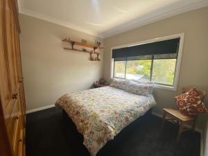 niewielka sypialnia z łóżkiem i oknem w obiekcie 56 Culgoa Crescent, Pambula Beach w mieście Pambula Beach