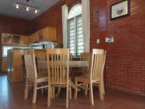 a kitchen with a table and chairs and a brick wall at Family Garden House at Tri An Lake, Đồng Nai in Ðồng Sài