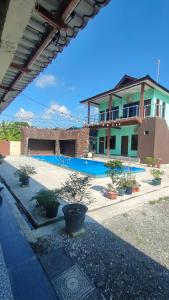 a house with a swimming pool in front of it at MAMA homestay in Bagan Serai