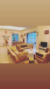 un grand salon avec des canapés et une télévision dans l'établissement Balishanan Homestay, à Gongzhao