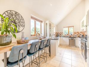a kitchen with a large island with stools at Rowan House in Carsington