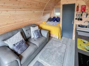 a living room with a couch and a bed in a tiny house at Sea Dreams in Theddlethorpe Saint Helen