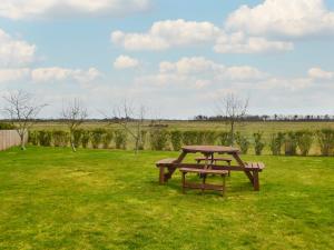 a picnic table in the middle of a field at Sea Dreams in Theddlethorpe Saint Helen