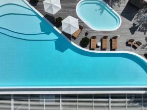 an overhead view of a swimming pool with chairs and umbrellas at The Heaven Resort in Ansan +37 photos