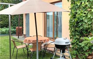un grill e un tavolo con ombrellone e barbecue di Lovely Home In Sianw With Kitchen a Sianów