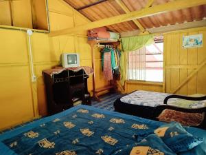 a bedroom with two beds and a tv in a room at Agradable granja cerca a un río de agua fresca. in Archidona