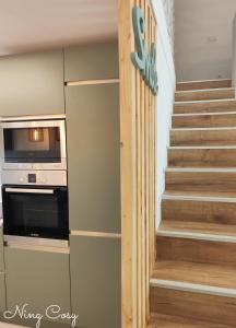 a staircase in a house with a microwave at Superbe Cosy Duplex Appartement T3 Charpenne Tête D'or avec parking privé gratuit in Villeurbanne