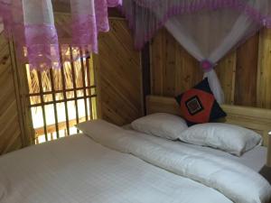 sypialnia z białym łóżkiem i czerwoną poduszką w obiekcie Chô Family w mieście Bac Ha