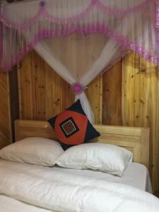 sypialnia z łóżkiem z zagłówkiem z baldachimem w obiekcie Chô Family w mieście Bac Ha