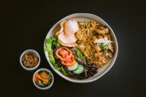 a bowl of food with rice and vegetables on a table at Ecozy Dijiwa Canggu in Canggu