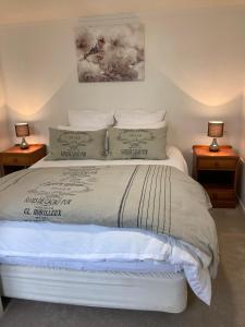 a bedroom with a white bed with two night stands at Rotorua Tranquility in Rotorua