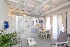 uma cozinha e sala de estar com mesa e cadeiras em Santa Katerina Apartments & Studios em Naxos Chora