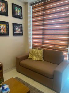 - un salon avec un canapé et une fenêtre dans l'établissement C2 Mactan, à Punta Engaño