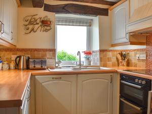 eine Küche mit einem Waschbecken und einem Fenster in der Unterkunft High Spy in Bassenthwaite