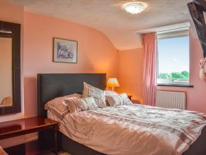 een slaapkamer met oranje muren en een bed met een raam bij High Spy in Bassenthwaite