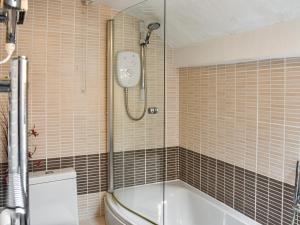 een badkamer met een douche, een bad en een toilet bij High Spy in Bassenthwaite