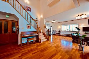 Morinoka - Vacation STAY 43707v في ماتسو: غرفة معيشة فيها بيانو ودرج