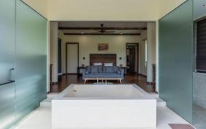 a large white tub in a living room with a couch at Casa XiX villa Venuestay in Vĩnh Phúc +17 photos