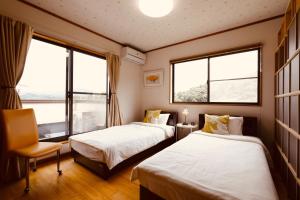 two beds in a room with two windows at Morinoka - Vacation STAY 43707v in Matsue