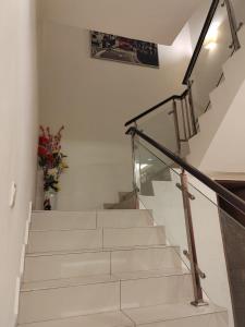 a staircase with a glass railing and a stair case at Nice semi D house at Tangkak in Tangkak