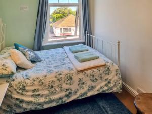 a small bedroom with a bed with a window at Hillrise in Herne Bay