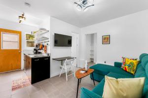 a living room with a blue couch and a kitchen at Seabreeze Hideaway B 30 Night Minimum in Honolulu