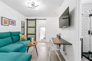 a living room with a blue couch and a table at Seabreeze Hideaway B 30 Night Minimum in Honolulu