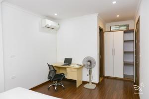 an office with a desk and a fan in a room at Pegasy Apartments & Travel in Hanoi
