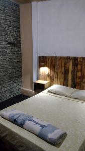 um quarto com uma cama e uma parede de tijolos em Liart Hospedajes em Puerto Iguazú