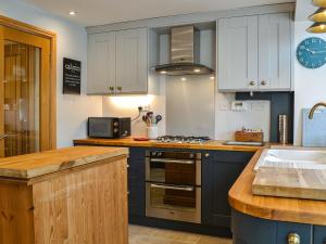 a kitchen with blue cabinets and a stove top oven at Rowan House in Beverley