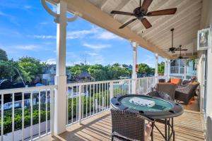 a porch with a table and a ceiling fan at Mojito Breeze Getaway home in Tavernier