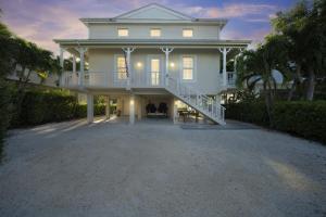 Casa blanca grande con porche y balcón en Mojito Breeze Getaway home, en Tavernier