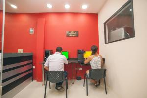a man and a woman sitting at a cash register at Hotel Luxor Pucallpa in Pucallpa