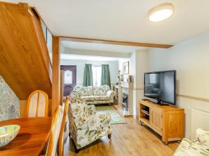 a living room with a television and a couch at Workshop Cottage in Rawcliffe