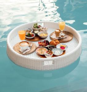a tray of breakfast foods and drinks in a pool at Rustic and Blue Getaway in Patong Beach