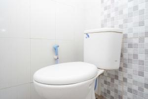 Un baño con un inodoro blanco en una habitación. en RedDoorz at Berlian Homestay Malioboro Yogyakarta, en Yogyakarta 21 fotos más