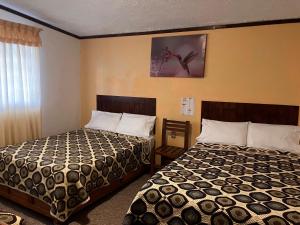 um quarto de hotel com duas camas e uma janela em Hotel Santa Fe em Chignahuapan