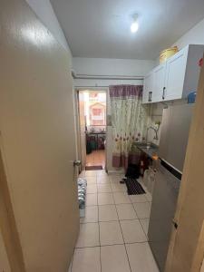 een keuken met een deur naar een keuken met een vloer bij AB HOMESTAY PUTERI BAHANG APARTMENT in Kota Kinabalu