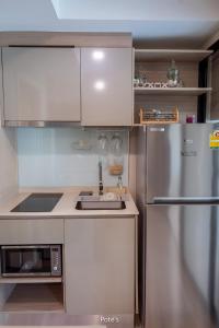 a kitchen with a stainless steel refrigerator and a sink at 2BR Condo near DMK Airport/Joddfairs/Chatuchak in Ban Chuat Plai Mai