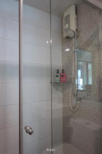 a shower with a glass door in a bathroom at 2BR Condo near DMK Airport/Joddfairs/Chatuchak in Ban Chuat Plai Mai