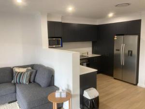 a living room with a couch and a kitchen at Kincaid@234 in Wagga Wagga