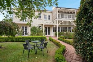 une table et des chaises devant un bâtiment dans l'établissement Clydesdale Manor, à Hobart