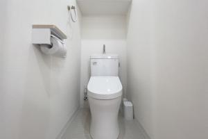 un bagno con un water bianco in una cabina di Sakuramichi Terrace a Tokyo